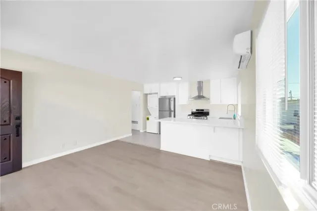 a view of a kitchen with kitchen island a sink wooden floor and a refrigerator