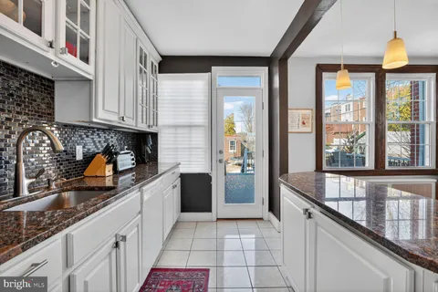 a kitchen with granite countertop a sink a counter top space and stainless steel appliances