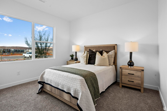 1624 South Staircase Way, Unit 4183 Washington, UT 84780 - Photo 28 of 47 Bedroom featuring a large window, neutral carpeting, white walls, light wood-finish bed frame, and coordinating nightstands