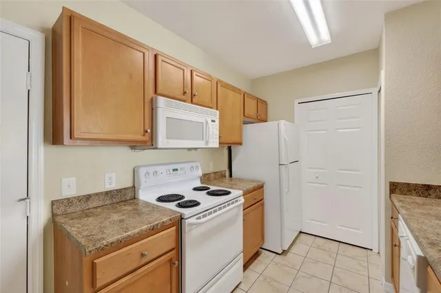 a kitchen with granite countertop a refrigerator and a stove top oven
