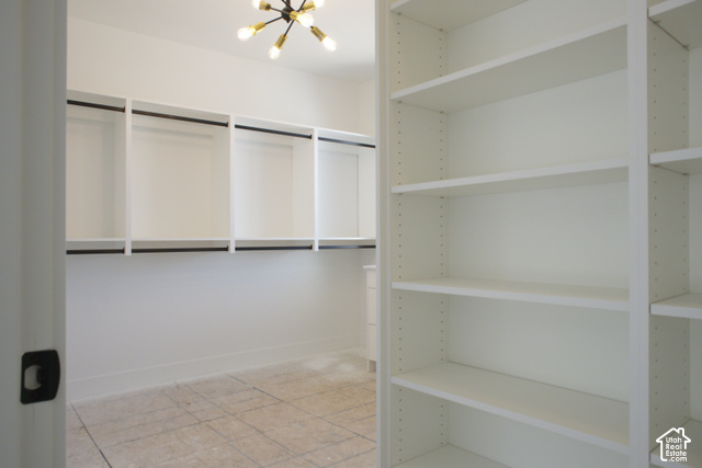 3504 North Sun Dancer Loop Logan, UT 84341 - Photo 33 of 59 Integrated closet system featuring white shelving, black hanging rods, and a Sputnik-style ceiling light