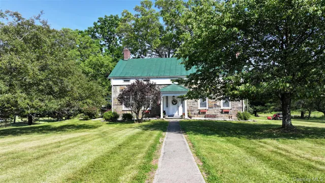 a view of a house with yard and sitting area