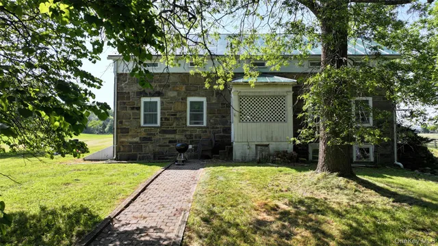 a view of a house with a big yard plants and large trees