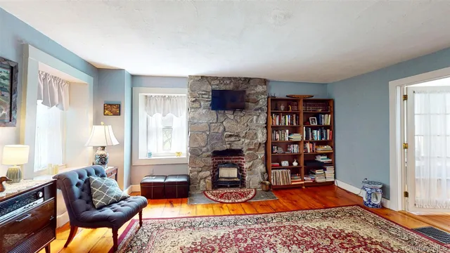 a living room with fireplace furniture and a rug