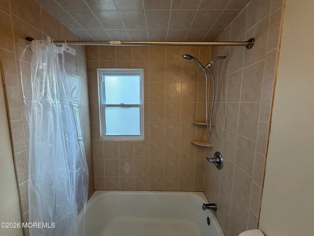 a bathroom with a shower and a bath tub