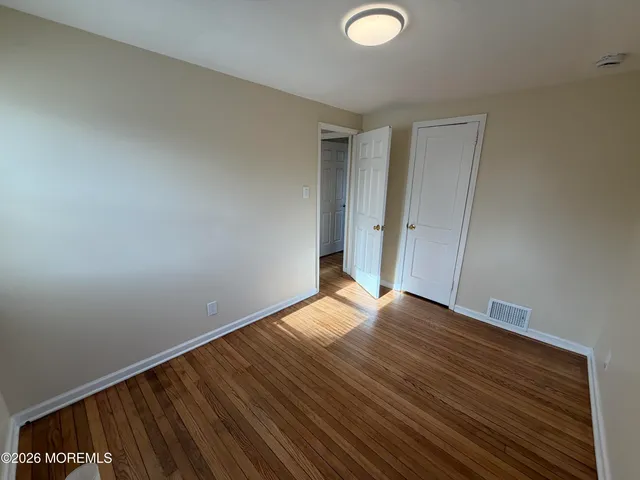 a view of an empty room and wooden floor