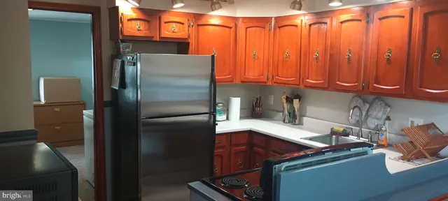 a kitchen with stainless steel appliances granite countertop a refrigerator and a sink