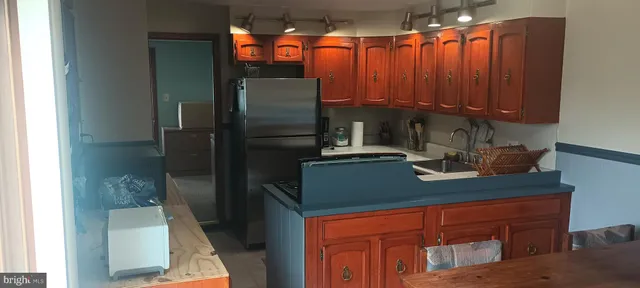 a kitchen with stainless steel appliances granite countertop a refrigerator and a sink