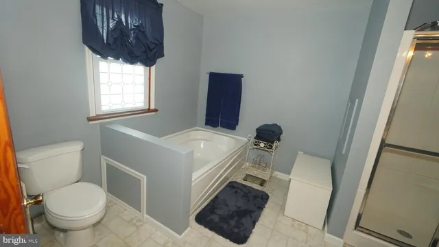 a bathroom with a toilet a sink and a window