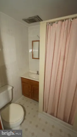a white toilet sitting next to a shower curtain