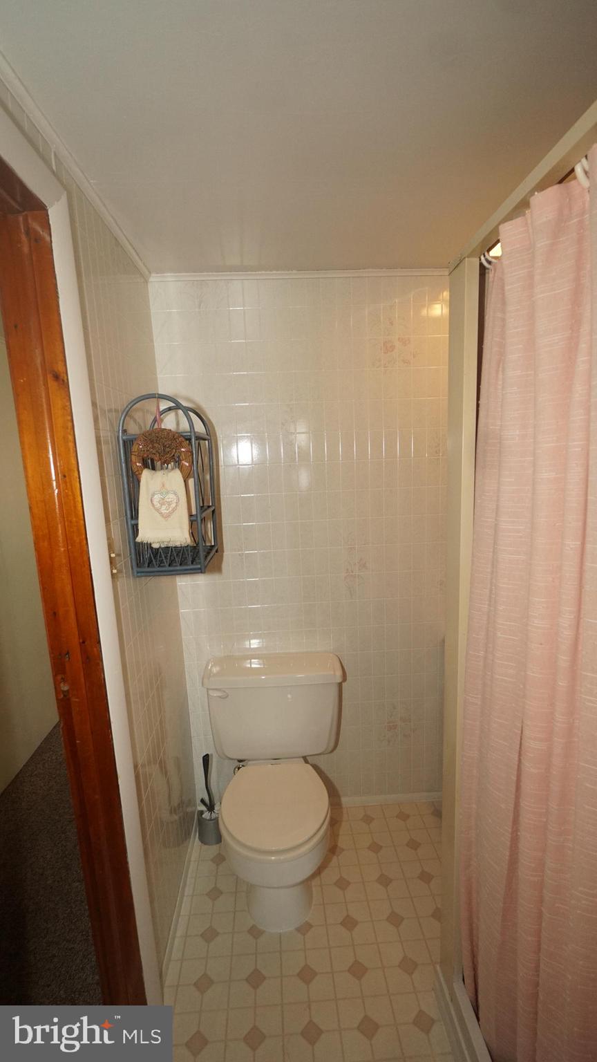 2307 State Rd. Croydon, PA 19021 - Photo 22 of 36 a white toilet sitting next to a shower curtain