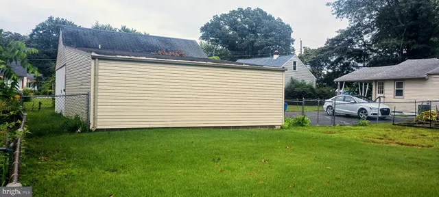 a view of a white house in the back yard