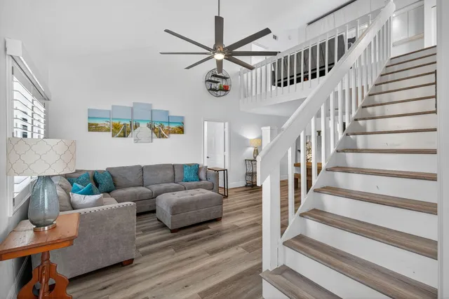 a living room with couches and a window with wooden floor