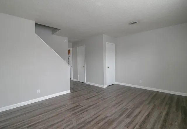 a view of an empty room with wooden floor