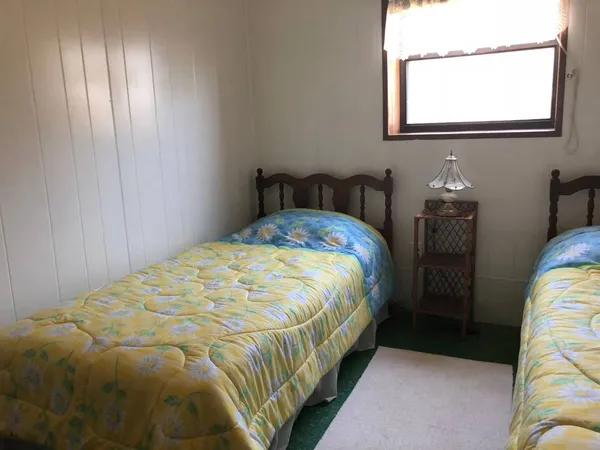 a bed sitting in a bedroom next to a window