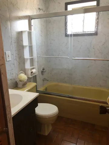 a bathroom with a granite countertop toilet a sink and bathtub