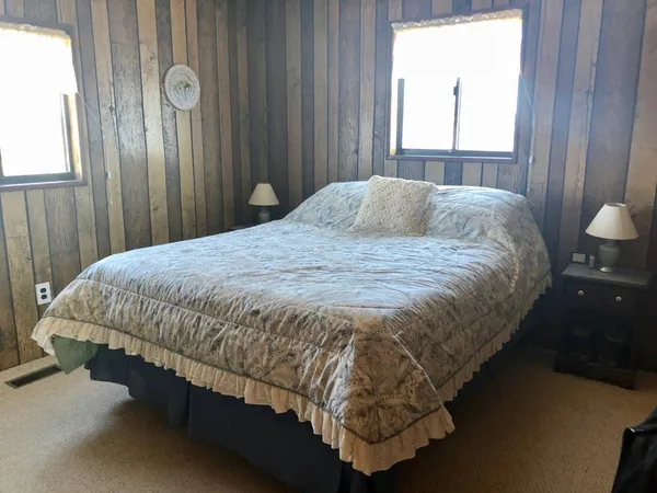 a bed sitting in a bedroom next to a window and a mirror