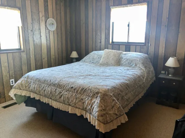 a bed sitting in a bedroom next to a window and a mirror