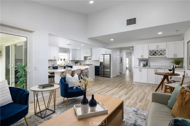 a living room with stainless steel appliances furniture and a view of kitchen