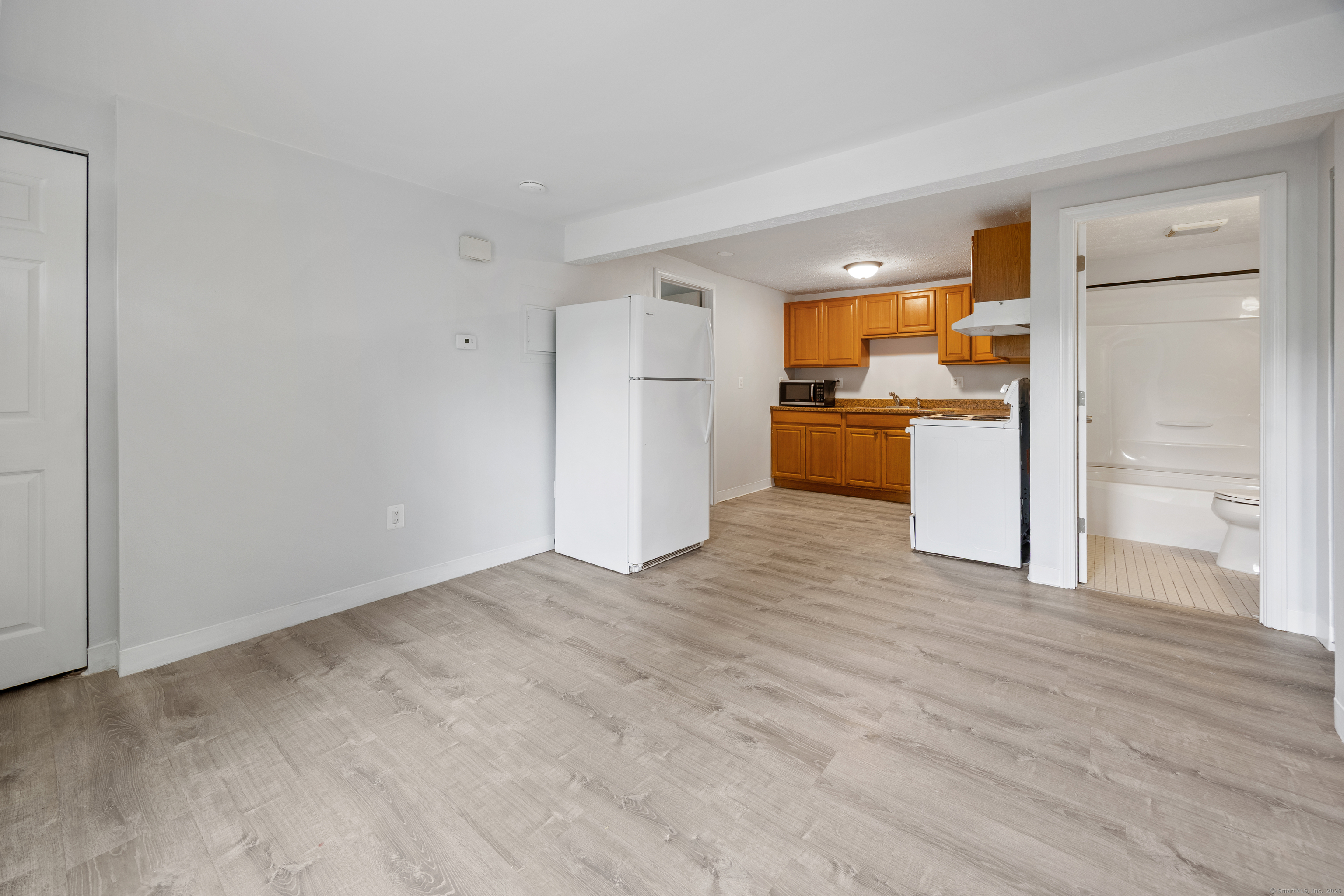 a view of a kitchen with a refrigerator a stove top oven and cabinets
