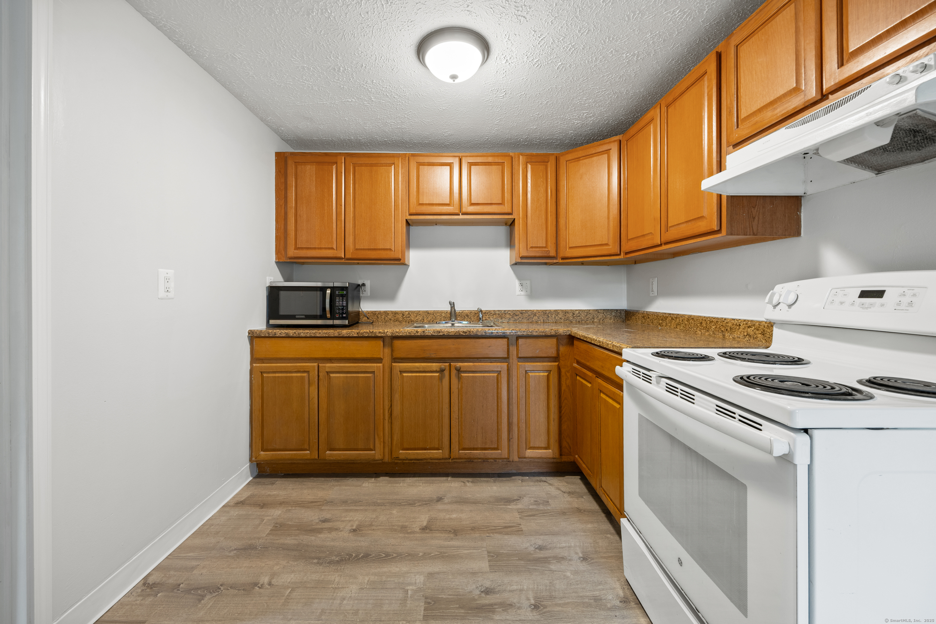 9 Guiel Place, Unit 1 Meriden, CT 06450 - Photo 3 of 15 a kitchen with a stove a sink and a microwave