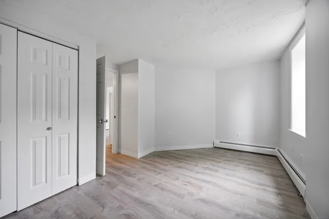 a view of an empty room with wooden floor