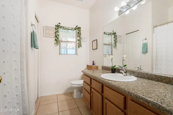 a bathroom with a granite countertop sink a toilet and a mirror