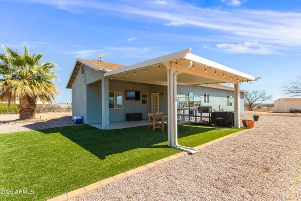 a view of a house with a yard patio and fire pit