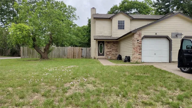 a view of a house with backyard and a tree