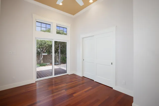 a view of a big room with wooden floor and windows