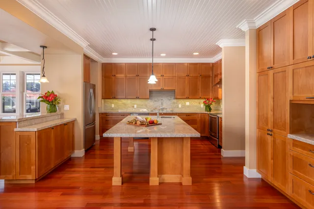 a kitchen with stainless steel appliances granite countertop a sink a stove and a refrigerator