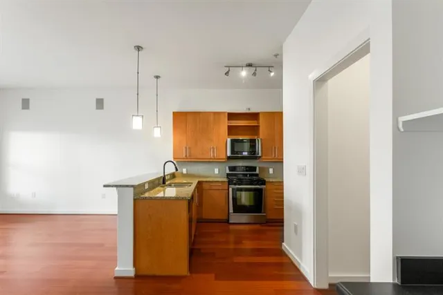 a kitchen with stainless steel appliances granite countertop a sink stove and refrigerator