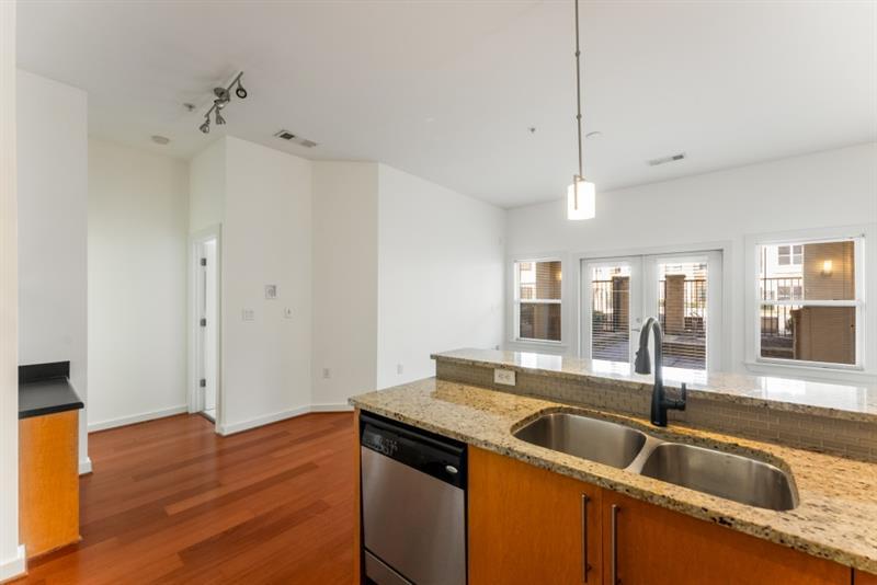 870 Inman Village Parkway Northeast, Unit 203 Atlanta, GA 30307 - Photo 6 of 43 a view of a kitchen with a sink and wooden floor