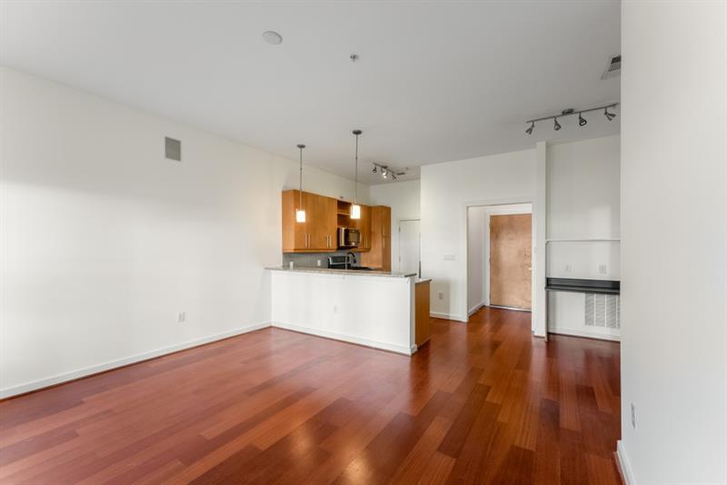 870 Inman Village Parkway Northeast, Unit 203 Atlanta, GA 30307 - Photo 8 of 43 a view of a hallway with wooden floor and a refrigerator
