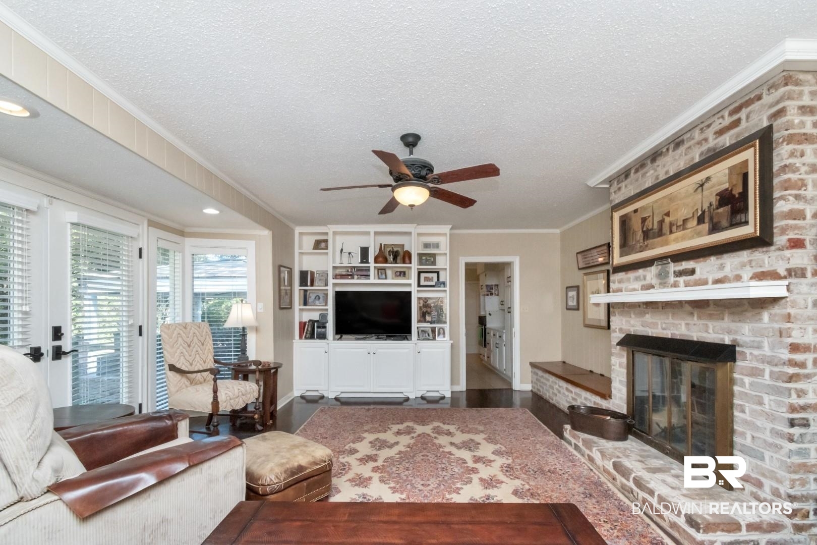 302 Springwood Drive East Mobile, AL 36608 - Photo 10 of 35 Living room featuring crown molding, wood-type flooring, a textured ceiling, and a brick fireplace