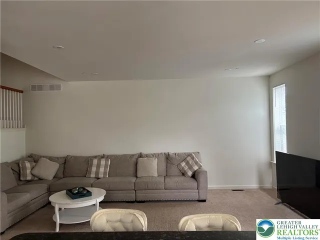 a living room with couches and a flat screen tv