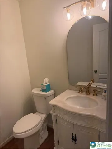 a bathroom with a toilet a sink and mirror