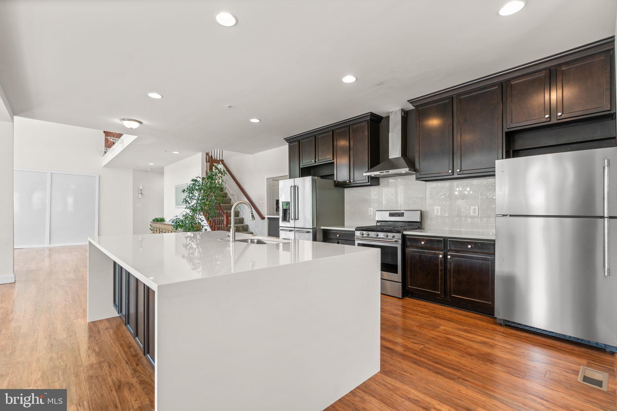 174 Acton Road Annapolis, MD 21403 - Photo 7 of 36 a kitchen with stainless steel appliances granite countertop a refrigerator a sink dishwasher a stove and a oven with wooden floor