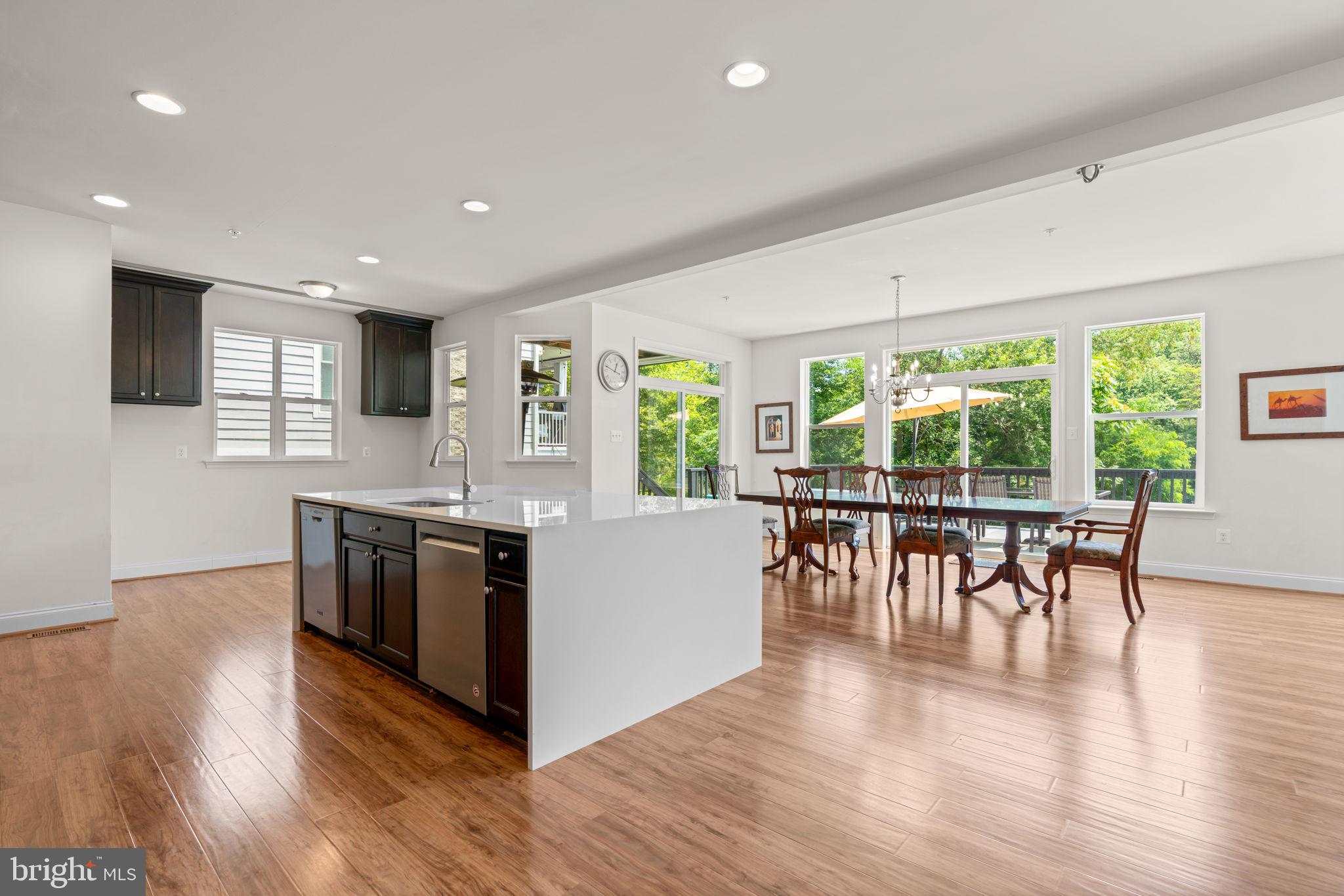 174 Acton Road Annapolis, MD 21403 - Photo 9 of 36 a kitchen with stainless steel appliances granite countertop a stove top oven a dining table and chairs with wooden floor