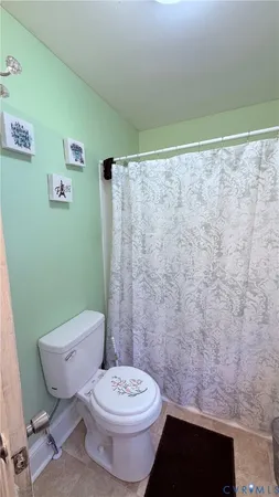 a white toilet sitting next to a shower curtain