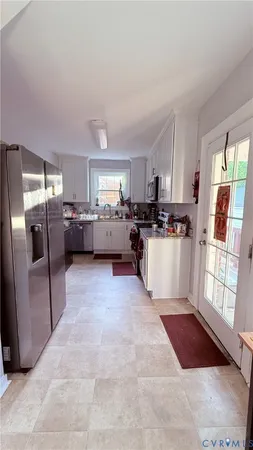 a kitchen with stainless steel appliances granite countertop a refrigerator stove top oven and sink
