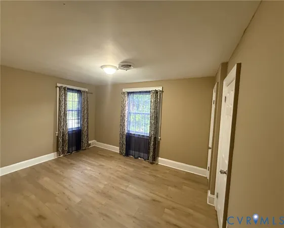 an empty room with windows and closet