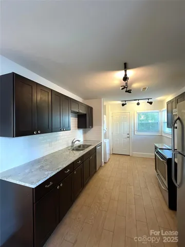 a large kitchen with a stove a sink and a refrigerator