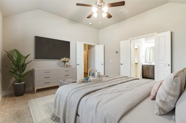 a bedroom with a large bed and a flat tv screen