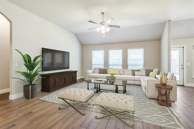 a living room with furniture potted plant and a flat screen tv