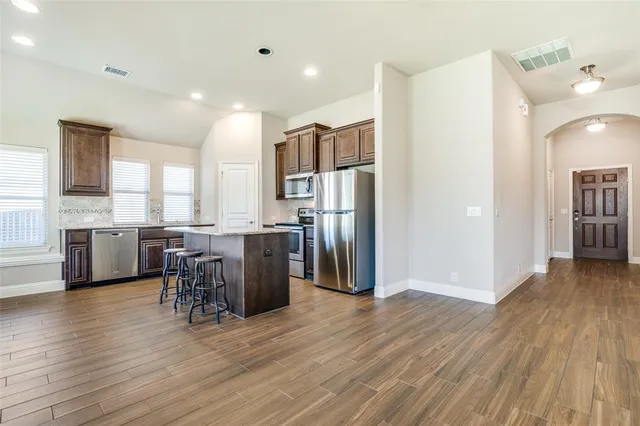 a view of kitchen with refrigerator and microwave