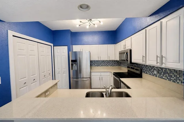 a kitchen with stainless steel appliances a refrigerator sink and cabinets