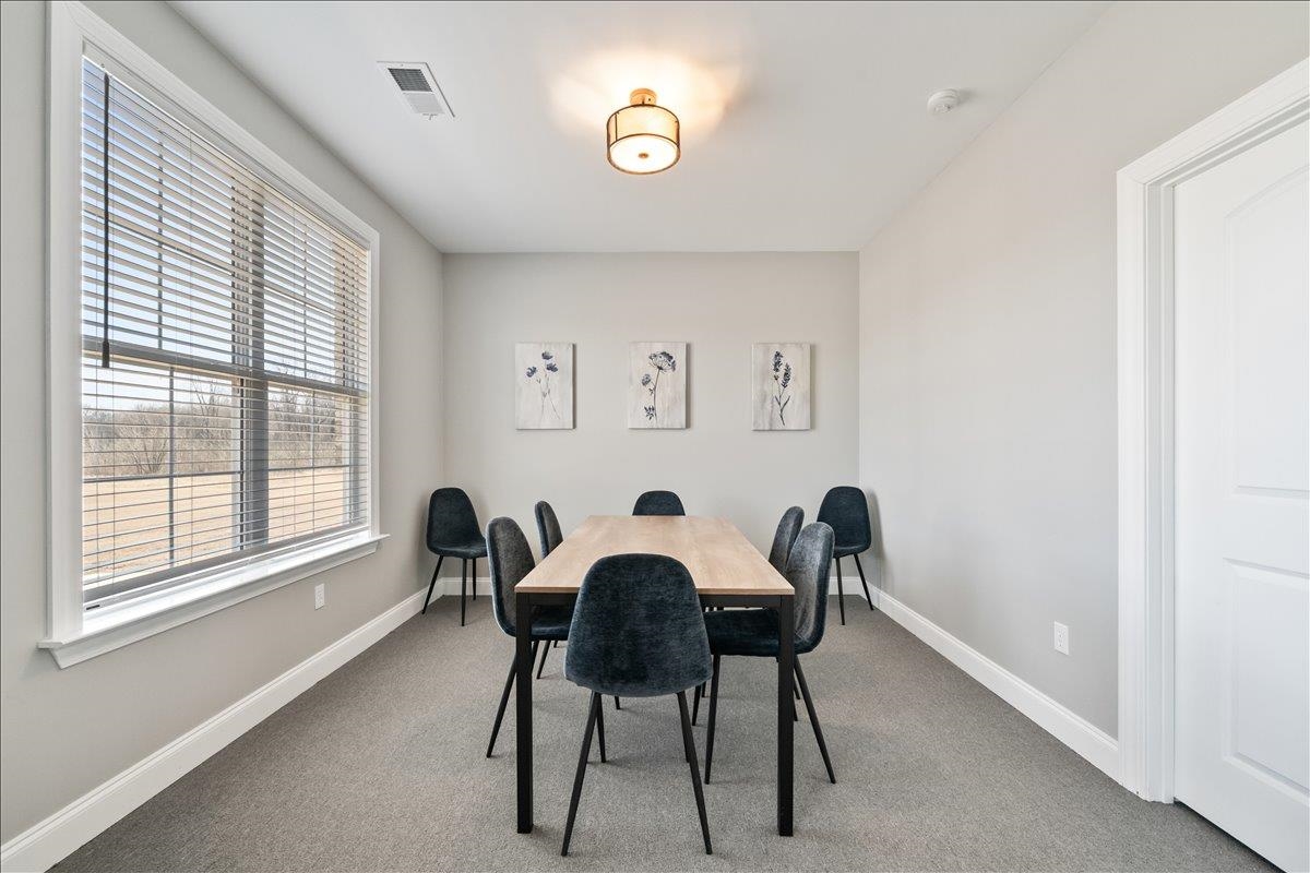 415 Abbey Road, Unit D Munford, TN 38058 - Photo 32 of 35 Carpeted room featuring a large window with blinds, a white paneled door, and a flush mount ceiling light
