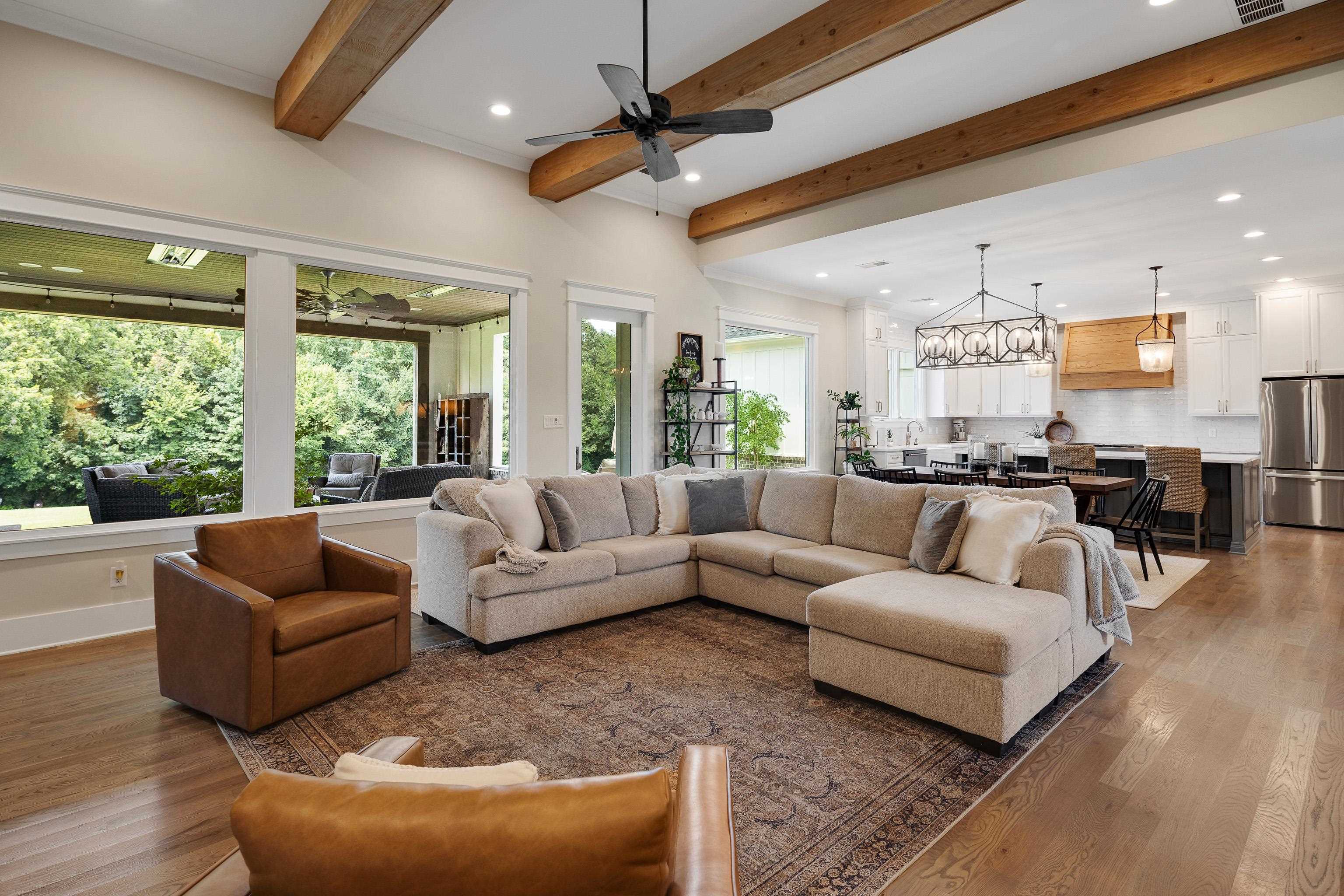 805 Shady Grove Road Williston, TN 38076 - Photo 10 of 40 Vaulted ceilings with exposed beams, recessed lighting, expansive windows, wood-finish flooring, and a contemporary kitchen with stainless steel appliances