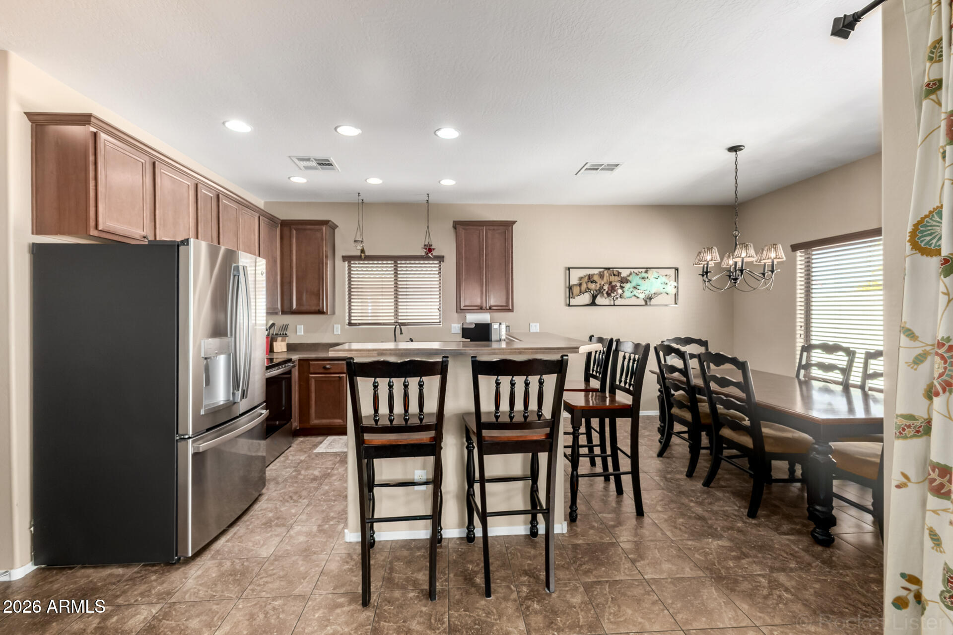 2756 South Powell Road Apache Junction, AZ 85119 - Photo 7 of 37 a kitchen with kitchen island a dining table chairs and refrigerator